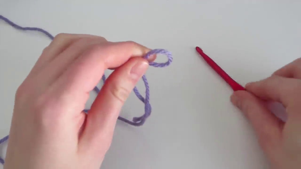 A visual guide showing the final step of creating a slip knot, with the loop secured on the crochet hook.