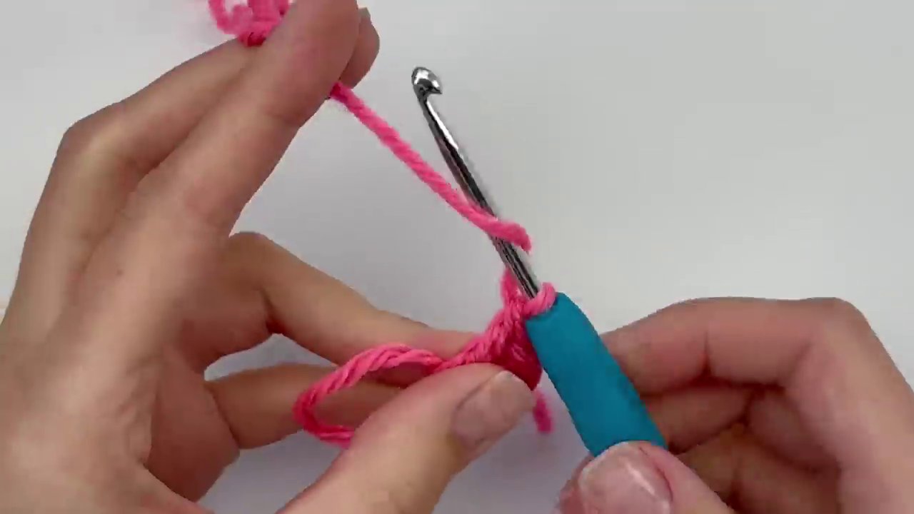 A clear shot of the first half of the heart taking shape, showing the progression from treble crochets to double crochets forming the rounded lobe.