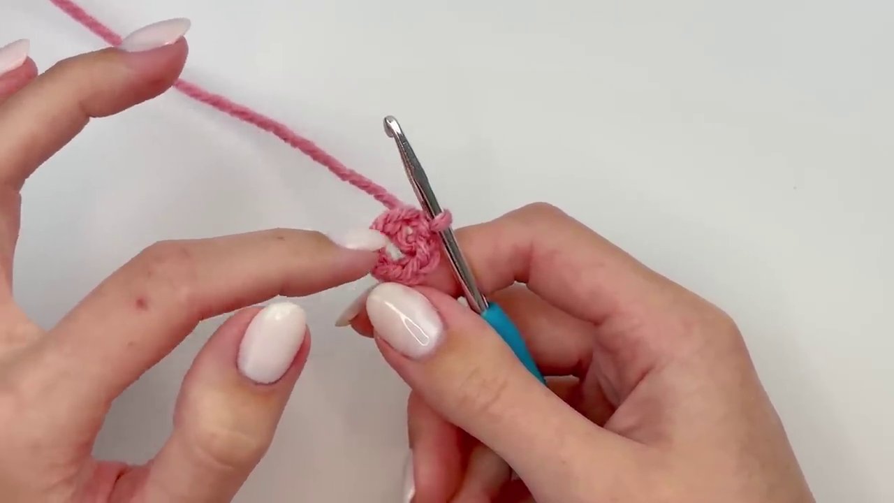 The first completed petal, showing the chain-4 arch, three triple crochets, and the final chain-4 arch before the slip stitch.