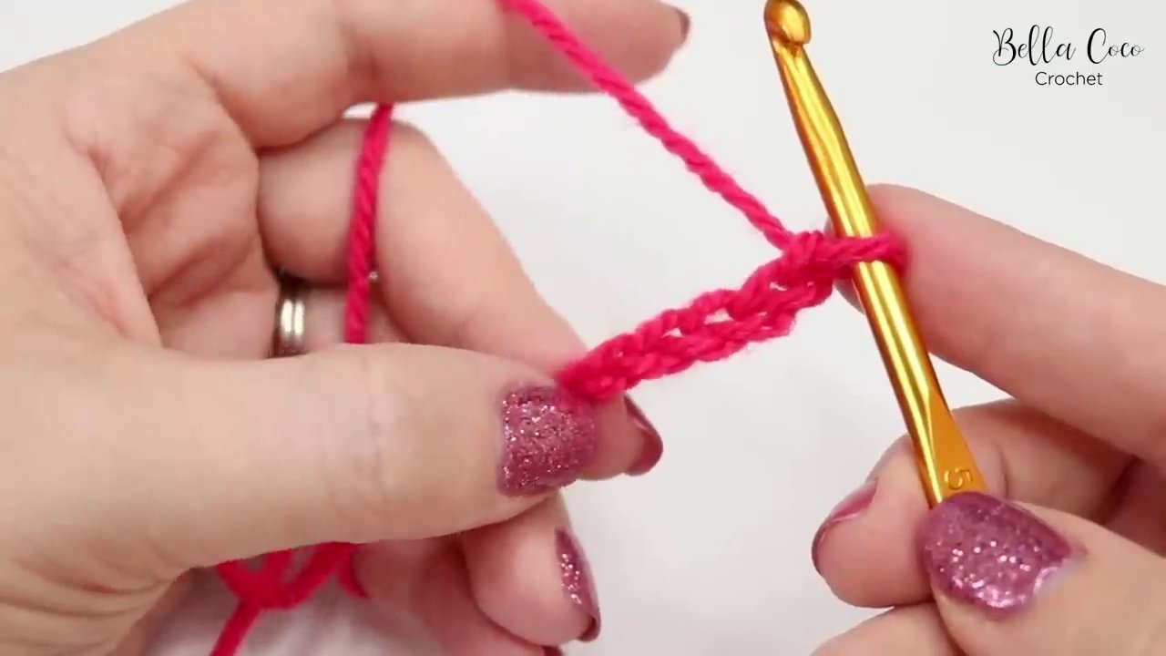 A completed chain of ten stitches, held up to show the distinct "V" shapes on the front.