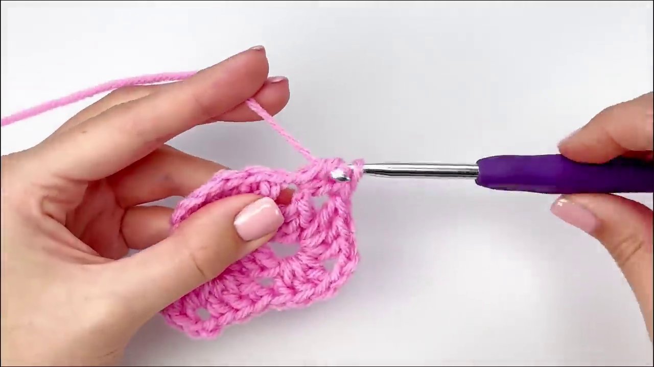 The nearly finished granny square after Round Four, clearly showing two side clusters between each corner.