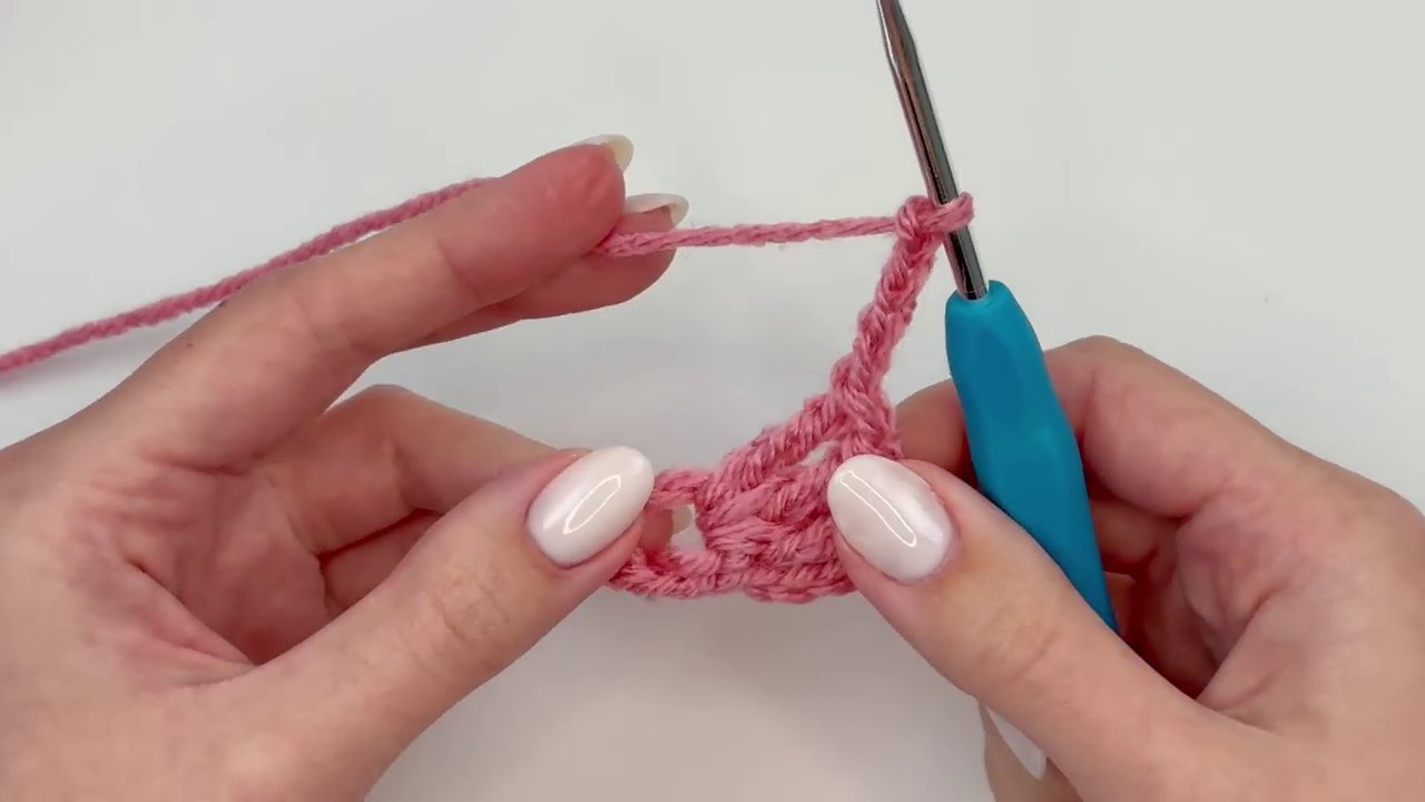 The final, perfect crochet flower held in hand, ready to be used as an appliqué, brooch, or decoration.