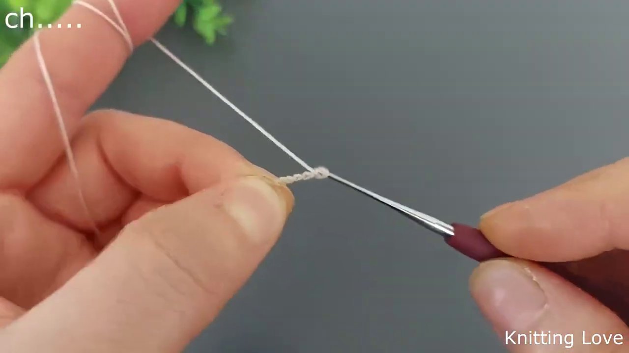 Close-up of the hook inserted into a stitch, with yarn being pulled through to form a double crochet.