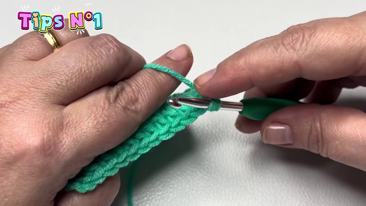 Hand position showing the yarn held behind the hook after turning the work to the left.