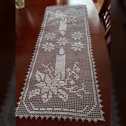 Close-up of a crochet hook working a double crochet stitch into a partially finished runner.
