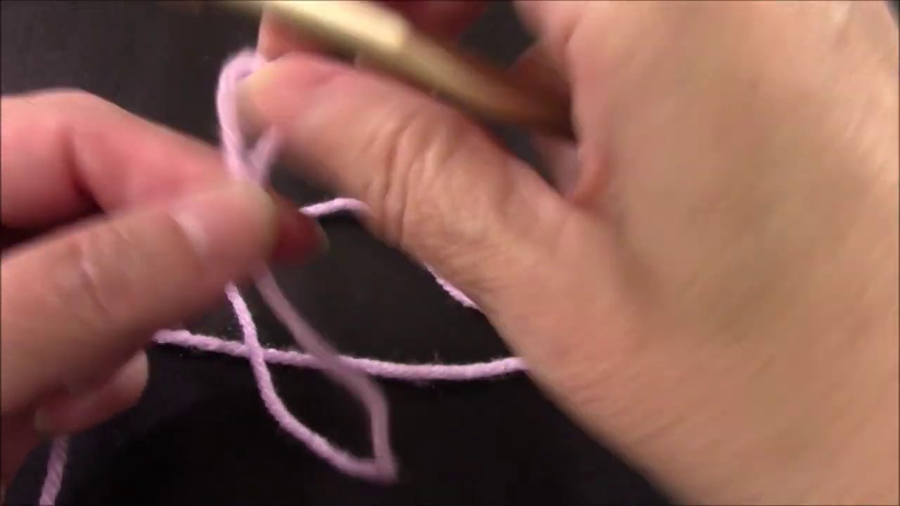 The hook inserted into the second-to-last chain, ready to pull through and complete the stitch.