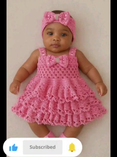 A striped crochet dress in purple, pink, and white with a center bow, photographed on a tiled floor.