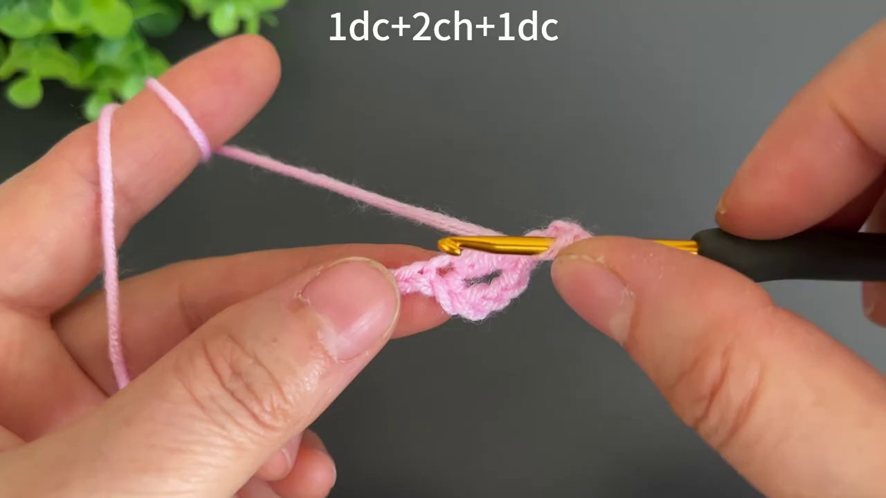 The gold hook works through a chain loop, with the pink fabric beginning to take shape underneath.