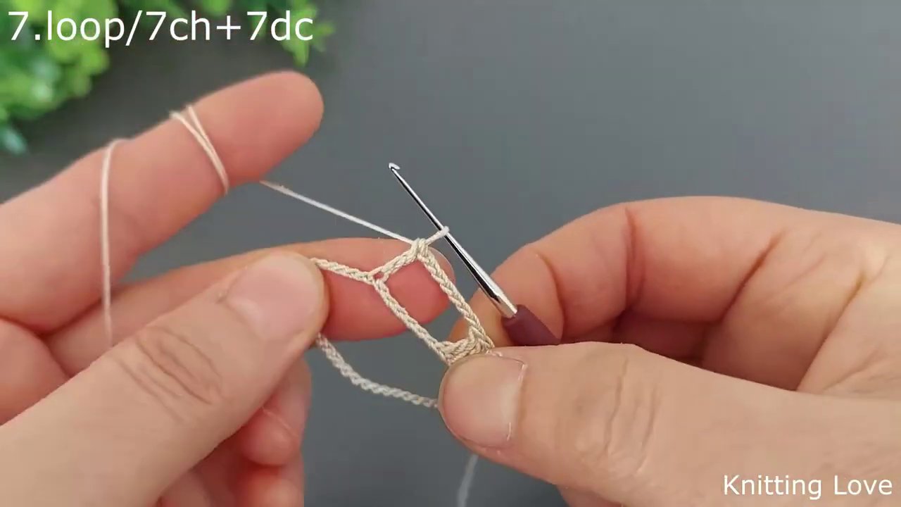 The hook forming a chain of five stitches, with the previous row’s double crochets visible below.