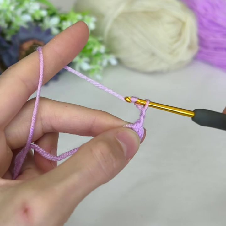 The white layer is nearly complete, with even stitches forming a clean ring around the purple center.