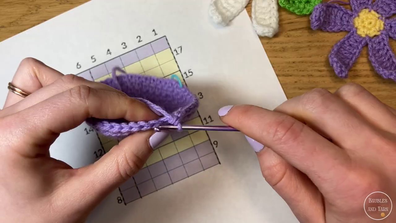 A color change in progress, showing the last yarn over with the new color being pulled through the loops.