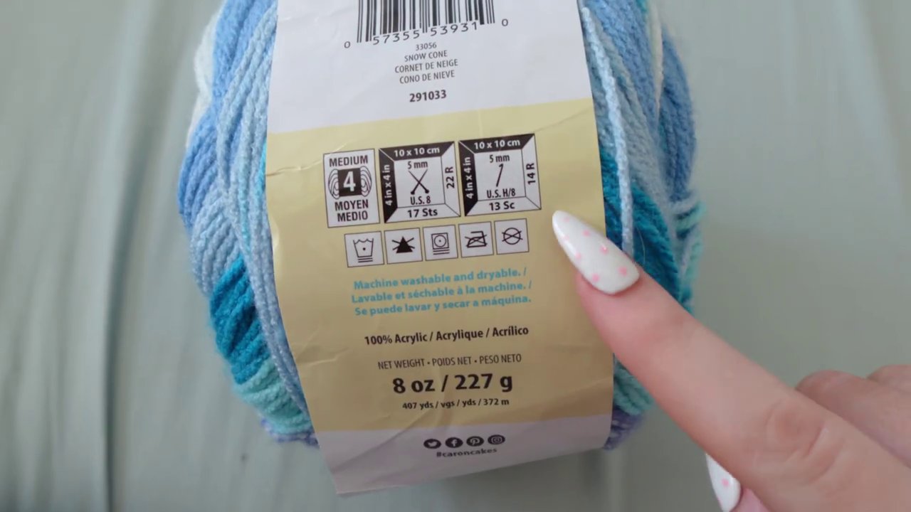 A yarn skein with its wrapper visible, showing the recommended hook size and gauge information.
