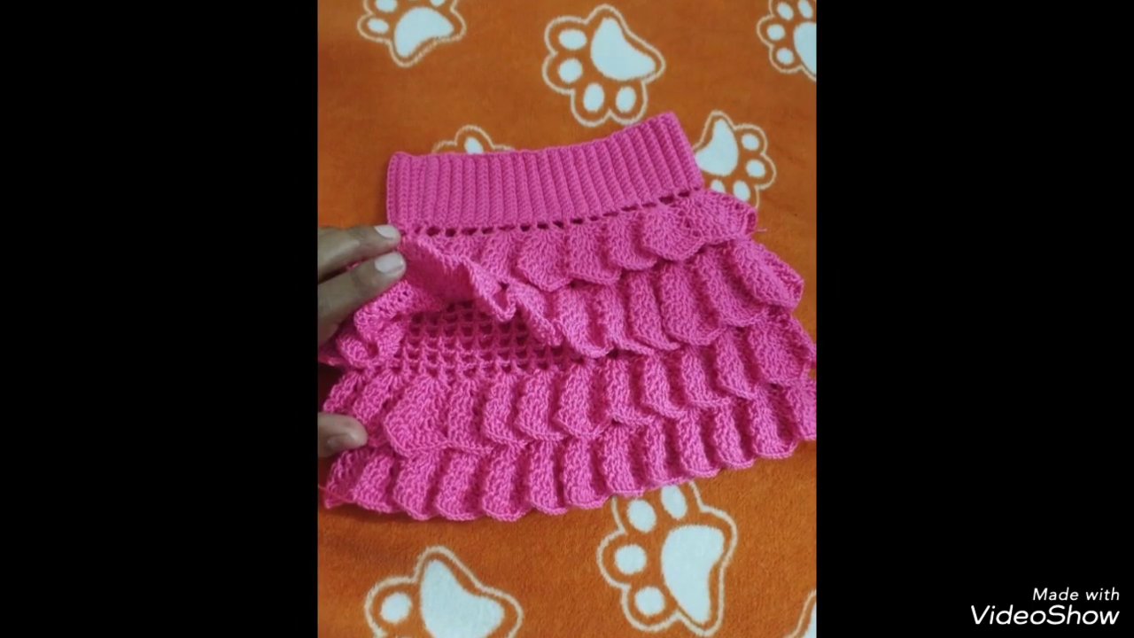 A crochet project in progress, with stitch markers and a tape measure nearby.