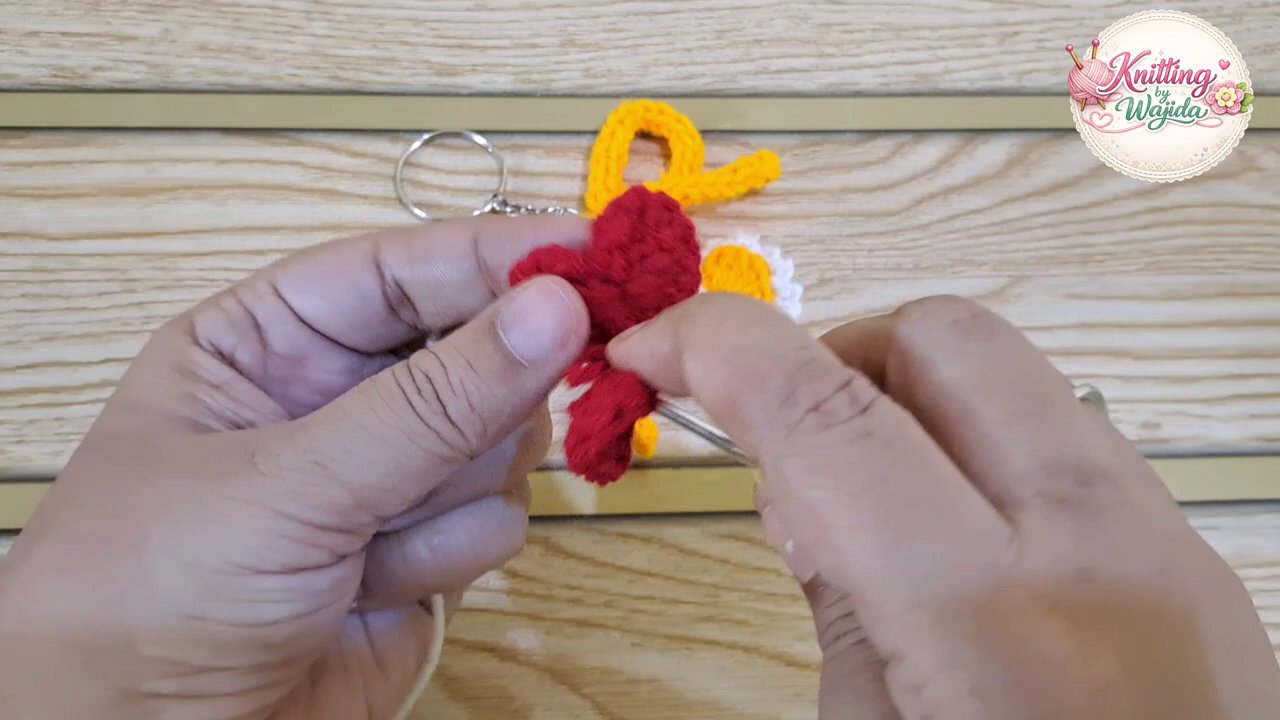 A close-up of the border being worked around the heart edge, showing the white yarn contrasted against the red.