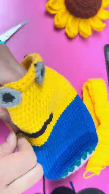The finished Minion bottle cover in a close-up shot, showing the complete face and overalls.