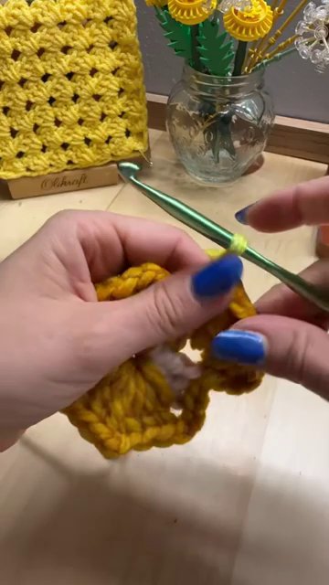 A large hexagon granny folded in half, with the fold line at the top and the two sides hanging down like sleeves.