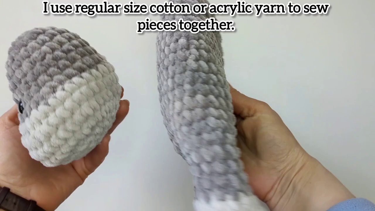 A crochet hook entering the center of a chenille stitch correctly to avoid splitting the yarn.