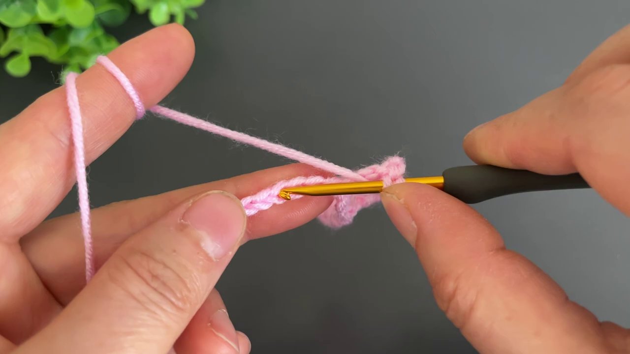 A close-up of the pink fabric shows the V-stitch pattern forming neat, open rows.