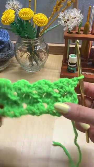 A baby blanket being worked in the tulip stitch, showing the light, airy fabric.
