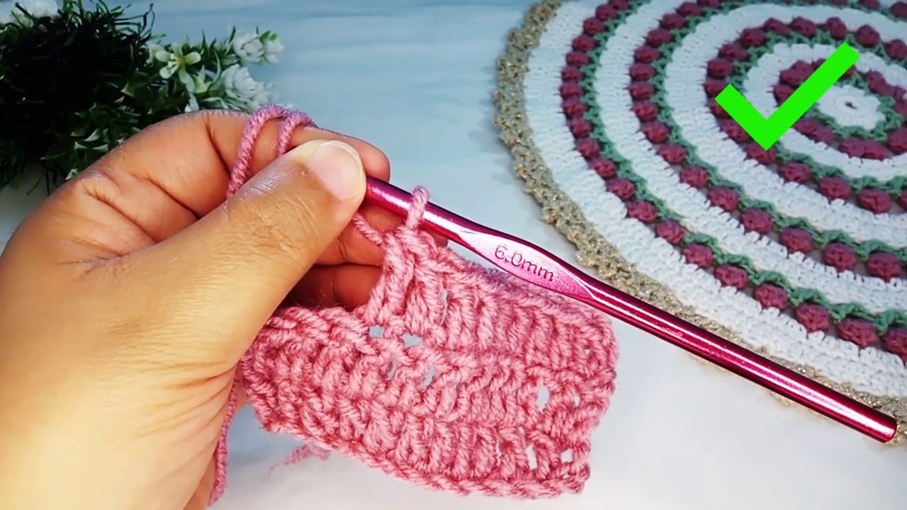 Hand holding yarn with proper tension, showing the yarn wrapped around the pinky and over the index finger.
