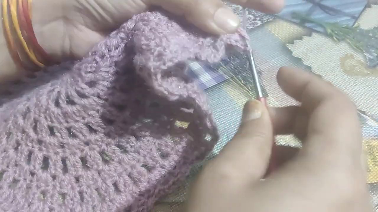 Weaving in the final yarn tails with a needle before trimming.