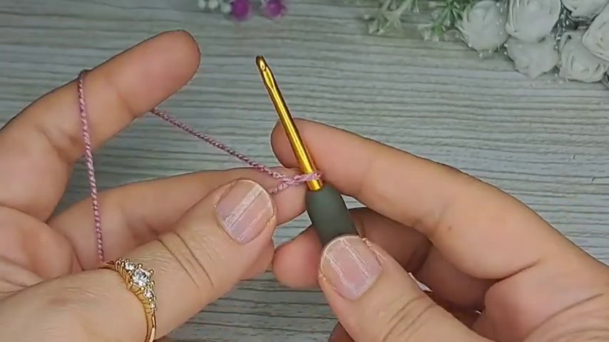 The hook is inserted around the post of a stitch from the row below, preparing to complete a front post single crochet.