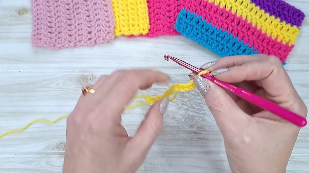 A hand demonstrating where to insert the hook into the second chain from the hook for a single crochet.