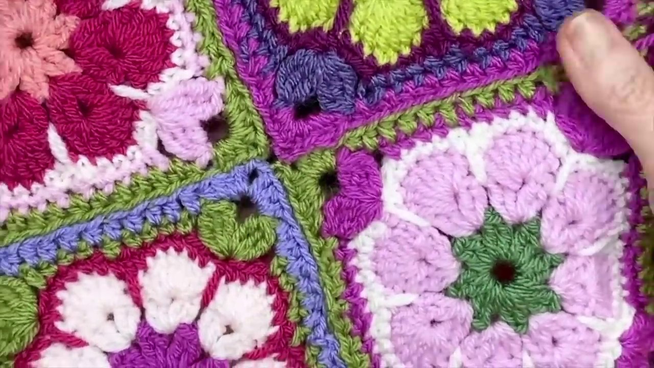 Two pieces of crochet fabric held together with a needle threaded through the centers of the stitches.