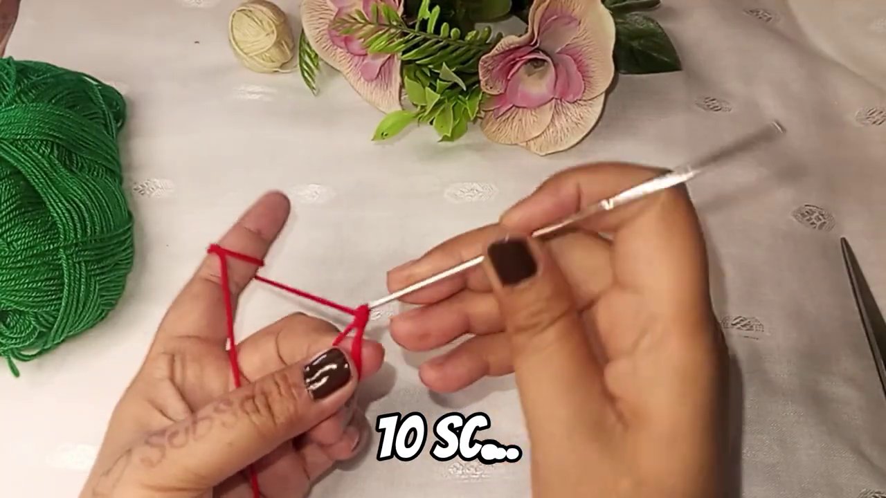 Green yarn being joined to the red circle, with single crochet stitches forming the rind.