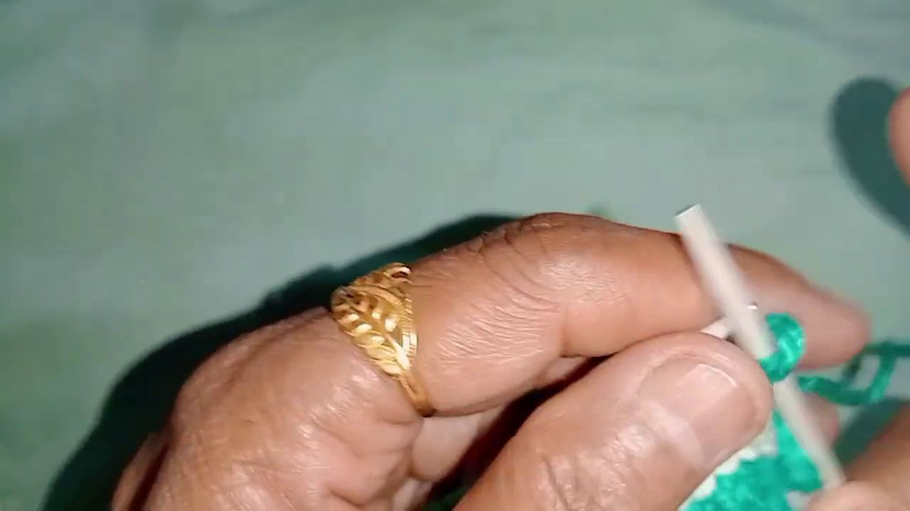 The knitter's hands holding the work, showing the color transition between two blocks.