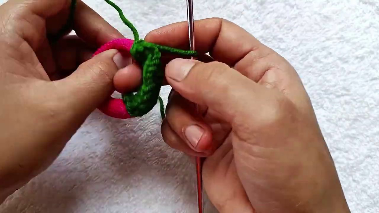 A finished scrunchie in pink and green, showing the contrast between the covered elastic and the ruffle.