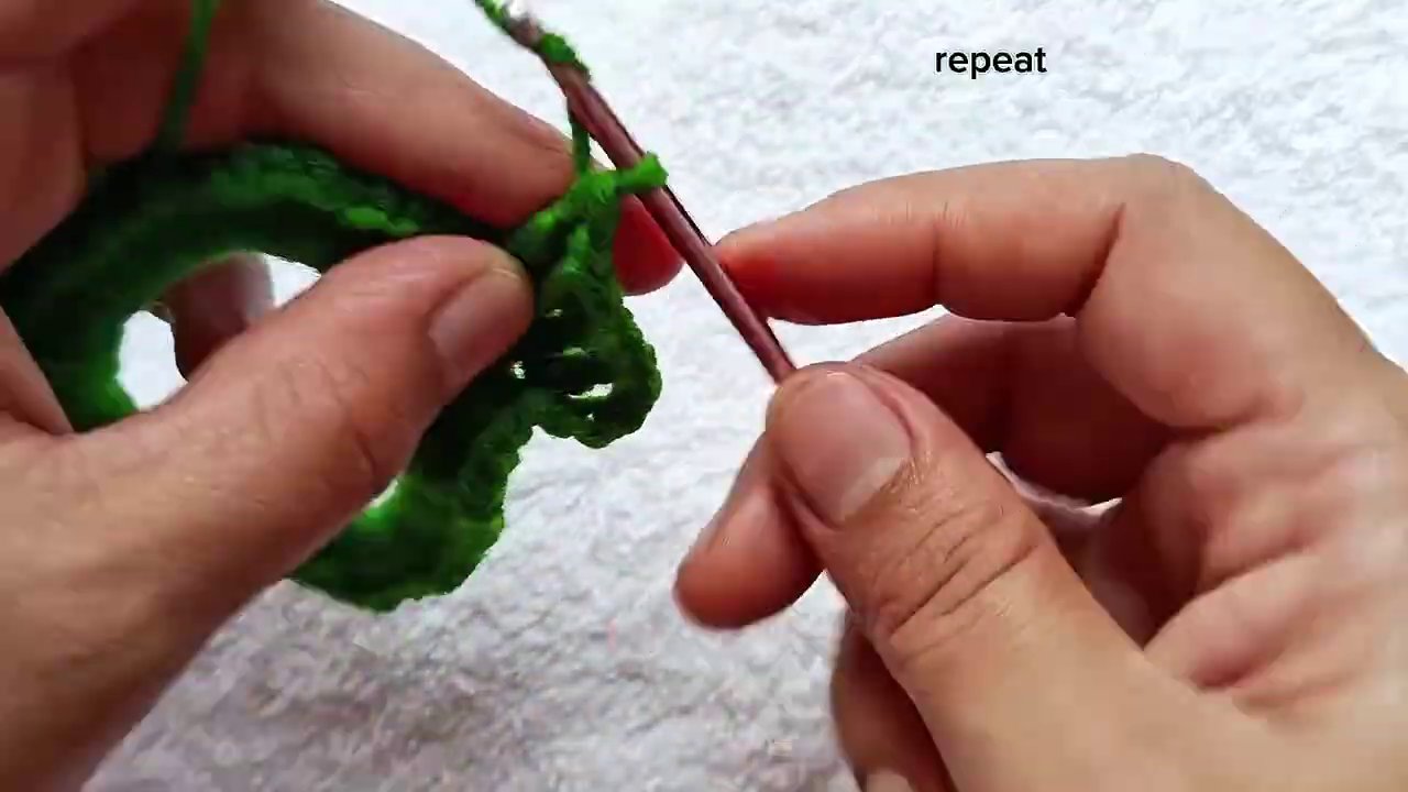 Weaving in the yarn tail with a needle to secure the end.