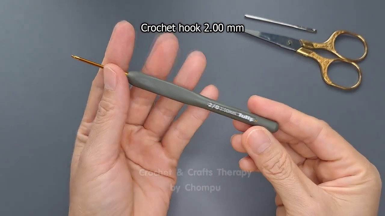 Close-up of the hook and yarn working the first single crochet stitches into the zipper tape.
