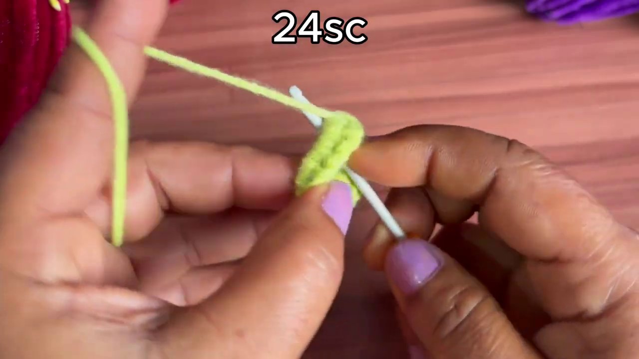 White yarn replaces yellow as the hands begin forming the flower’s base layer.