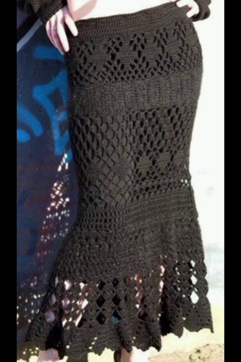 A delicate crochet table runner with an open lace pattern draped over a dining table.