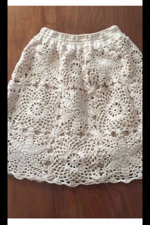 A crocheted beanie with embroidered floral motifs in contrasting colors.