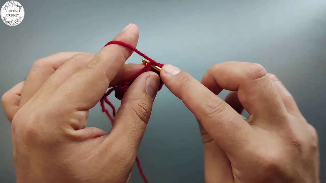 Pink yarn being looped around the hook, with multiple stitches visible from the previous rows.