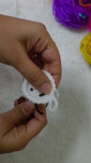 Several completed petals in different colors around the white base circle.