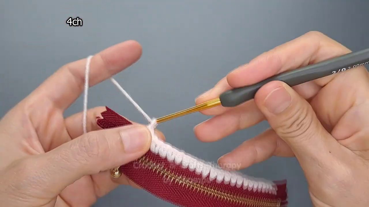 Flattened crocheted tube with a yarn needle ready to sew the bottom closed.