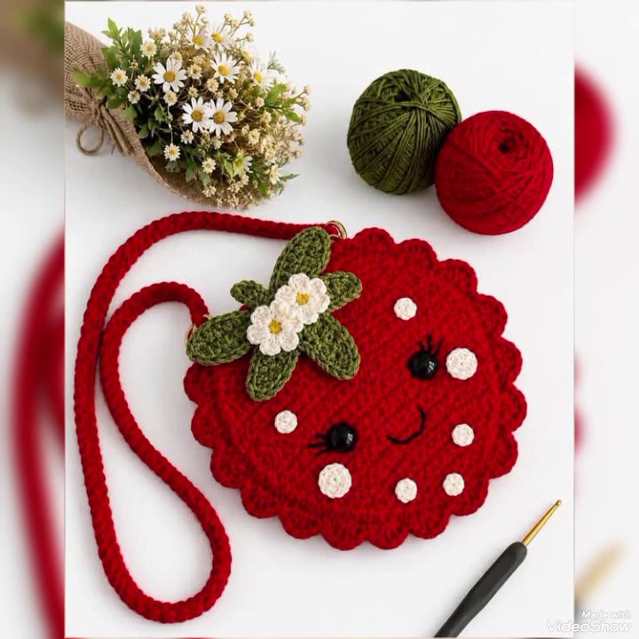 A pair of crochet earrings resting on a velvet jewelry tray, next to a small pair of scissors.