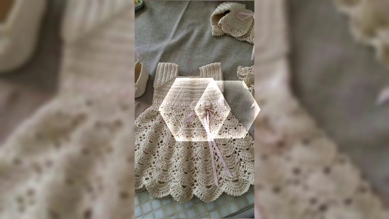 The finished floral cross stitch mounted in a simple wooden frame, displayed on a shelf next to a potted plant.