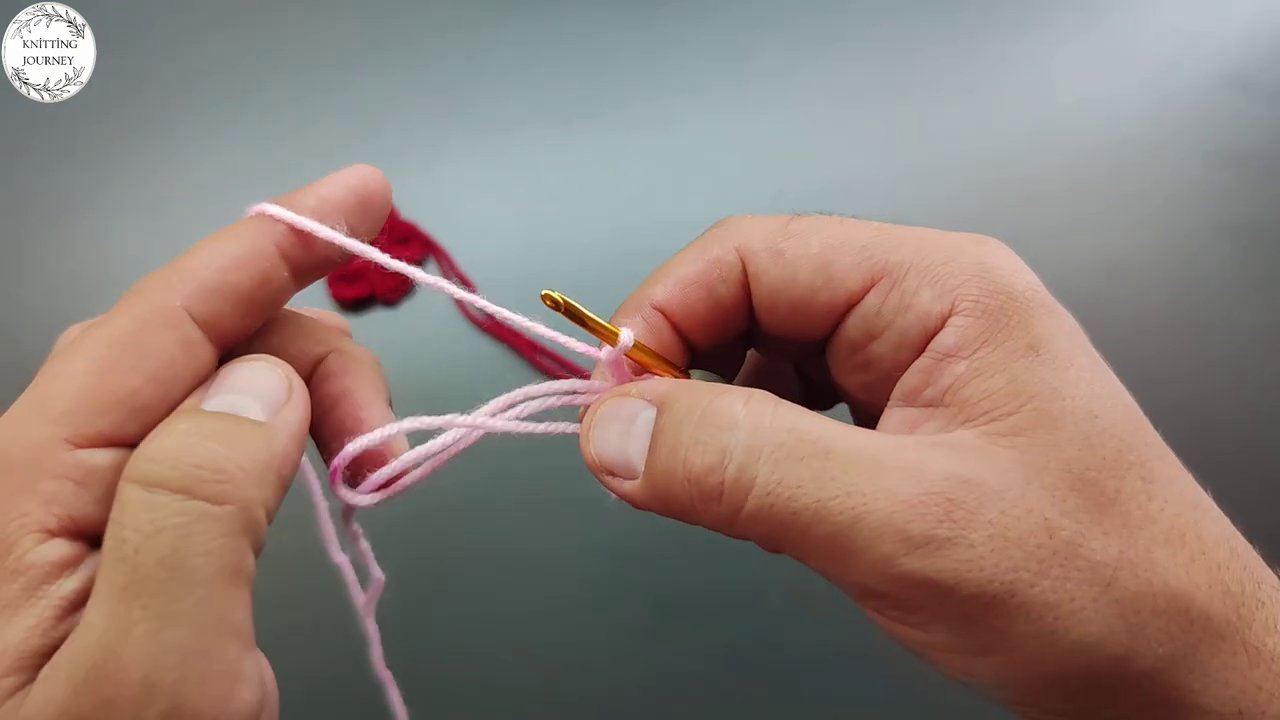 Hands adjusting the yarn tension against the stick frame, ensuring even spacing.