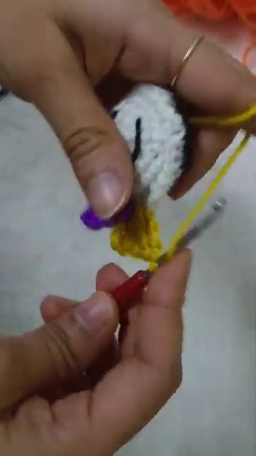 A finished keychain clipped onto a canvas tote bag, showing it in use.